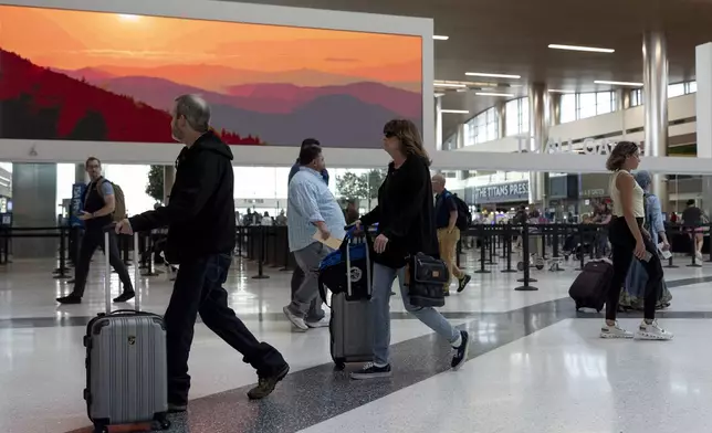 Travelers make their way through the Nashville international Airport, Thursday, May 23, 2024, in Nashville, Tenn. A record number of Americans are expected to travel over the 2024 Memorial Day holiday. (AP Photo/George Walker IV)