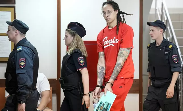 FILE - WNBA star and two-time Olympic gold medalist Brittney Griner, second from right, is escorted to a courtroom for a hearing in Khimki outside Moscow, Russia, July 7, 2022. Griner continues her efforts to settle into a normal routine following her release from a Russian prison 17 months ago. (AP Photo/Alexander Zemlianichenko, File)