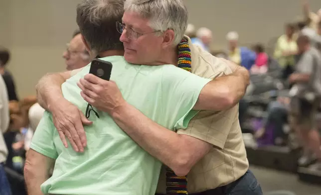 FILE - In this June 19, 2014, file photo, Gary Lyon, left, and Bill Samford celebrate after a vote allowing Presbyterian pastors discretion in marrying same-sex couples at the 221st General Assembly of the Presbyterian Church at Cobo Hall, in Detroit. When the United Methodist Church removed anti-LGBTQ language from its official rules in recent days, it marked the end of a half-century of debates over LGBTQ inclusion in mainline Protestant denominations. The moves sparked joy from progressive delegates, but the UMC faces many of the same challenges as Lutheran, Presbyterian and Episcopal denominations that took similar routes, from schisms to friction with international churches to the long-term aging and shrinking of their memberships. (David Guralnick/Detroit News via AP, file)