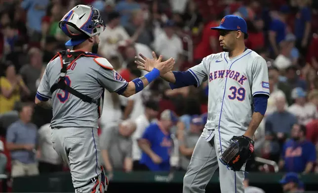 New York Mets relief pitcher Edwin Diaz (39) and catcher Tomas Nido celebrate a 4-3 victory over the St. Louis Cardinals in a baseball game Monday, May 6, 2024, in St. Louis. (AP Photo/Jeff Roberson)