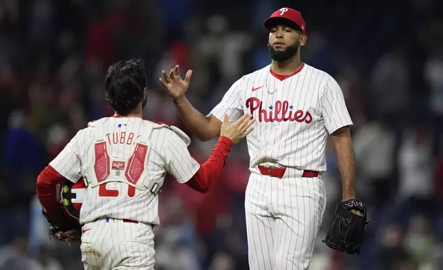 Philadelphia Phillies' Seranthony Dominguez, right, and Garrett Stubbs celebrate after the Phillies won a baseball game against the New York Mets, Wednesday, May 15, 2024, in Philadelphia. (AP Photo/Matt Slocum)