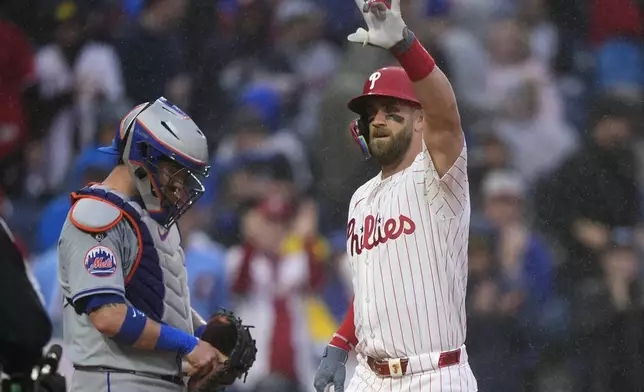 Philadelphia Phillies' Bryce Harper, right, reacts past New York Mets catcher Tomas Nido after hitting a home run during the first inning of a baseball game, Wednesday, May 15, 2024, in Philadelphia. (AP Photo/Matt Slocum)