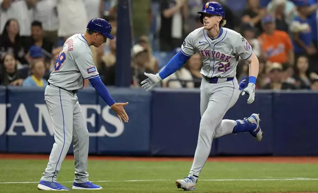New York Mets' Brett Baty (22) celebrates with third base coach Mike Sarbaugh after hitting a three-run home run off Tampa Bay Rays starting pitcher Aaron Civale during the second inning of a baseball game Friday, May 3, 2024, in St. Petersburg, Fla. (AP Photo/Chris O'Meara)