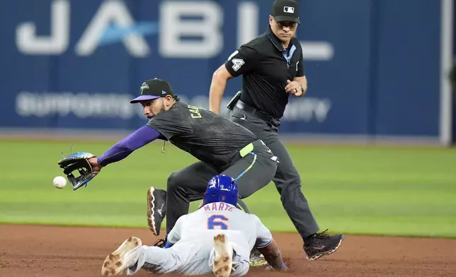 New York Mets' Starling Marte (6) steals second base ahead of the throw to Tampa Bay Rays shortstop Jose Caballero during the eighth inning of a baseball game Saturday, May 4, 2024, in St. Petersburg, Fla. Looking on is umpire Mark Wegner. (AP Photo/Chris O'Meara)