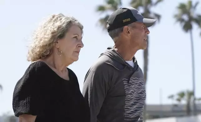 In this image taken from video, Australia's Debra Robinson stands with her husband Martin, following a media conference on the beach in San Diego, Tuesday, May 7, 2024 following the deaths in Mexico of their two sons during a surfing trip. The sons, Callum and Jake, and U.S. friend Jack Carter Rhoad, were allegedly killed by car thieves in Baja California, across the border from San Diego, somewhere around April 28 or 29. (Channel 9/POOL via AP)
