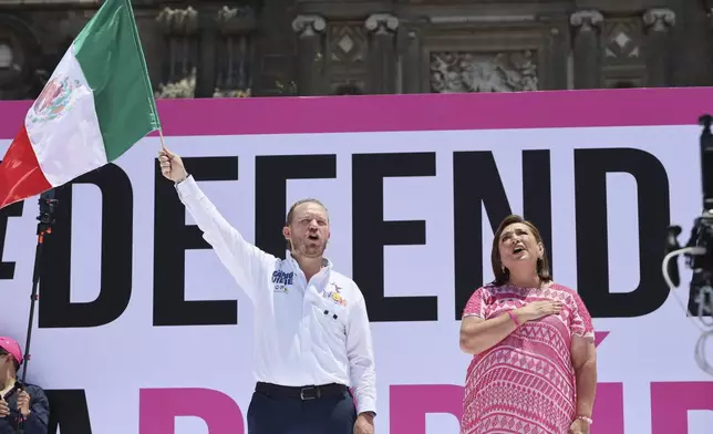 Presidential candidate Xochitl Galvez, right, sings the anthem alongside Santiago Taboada, candidate for Mexico City's chief of government, in an opposition rally ahead of June 2 general elections in the Zocalo, Mexico City's main square, Sunday, May 19, 2024. (AP Photo/Ginnette Riquelme)