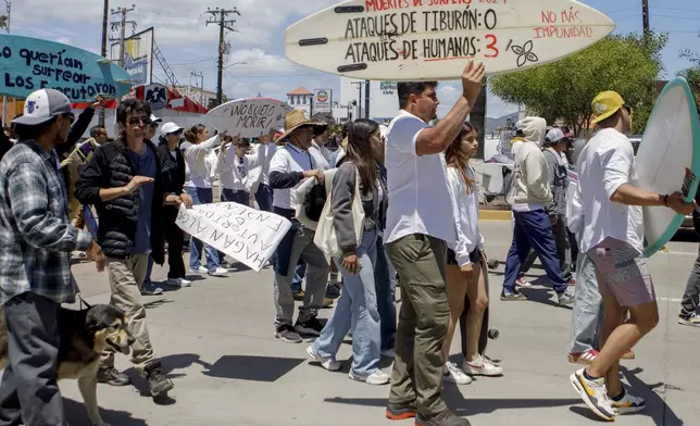 Locals march to protest the disappearance of foreign surfers in Ensenada, Mexico, Sunday, May 5, 2024. Mexican authorities said Friday that three bodies were recovered in an area of Baja California near where two Australians and an American went missing last weekend during an apparent camping and surfing trip. (AP Photo/Karen Castaneda)