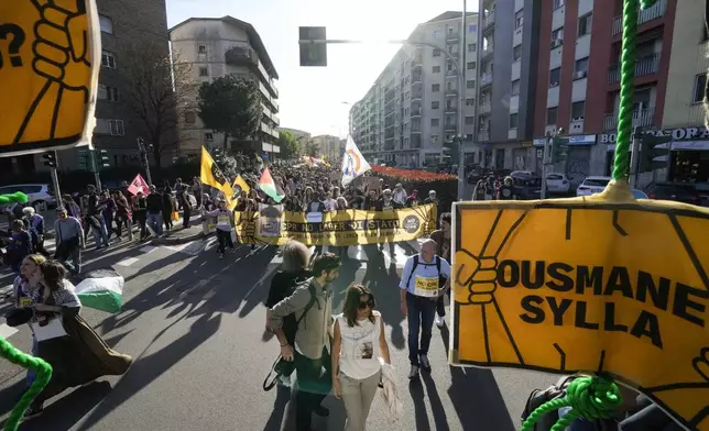 Demonstrators hold signs with the name of Ousmane Sylla, as they ask for the closure of all the facilities created in Italy to detain migrants in Milan. (AP Photo/Luca Bruno)