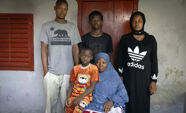 The mother and siblings of the late Ousmane Sylla gather for a photograph at their house after his funeral in Matoto Bonagui, a suburb in Conakry, Guinea, Tuesday, April 9, 2024. (AP Photo/Misper Apawu)