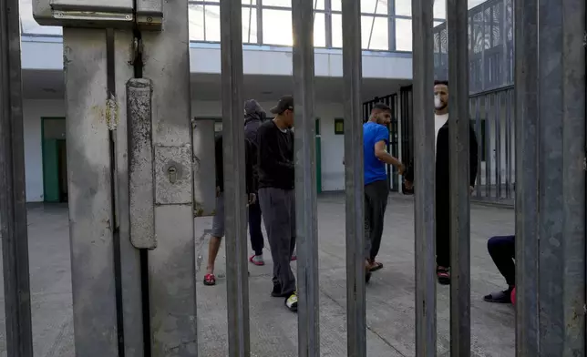 Detainees gather in an open area of the Ponte Galeria center, one of the facilities created in Italy to hold migrants ahead of their repatriation, as they are considered ineligible for refugee status or international protection, in Rome, Tuesday, March 19, 2024. (AP Photo/Andrew Medichini)