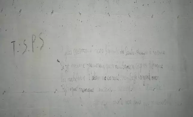 Writings left by Ousmane Sylla, a 21-year-old Guinean, are seen on a wall of the Ponte Galeria center in Rome, Tuesday, March 19, 2024, at the site of his apparent suicide. He was held in one of the facilities created in Italy to detain migrants ahead of their repatriation, as they are considered ineligible for refugee status or international protection, (AP Photo/Andrew Medichini)