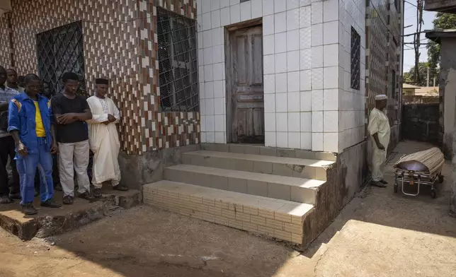 Allassane Sylla, foreground left at center, brother of the late Ousmane Sylla, stands with mourners performing the final funeral prayer outside a mosque in Matoto Bonagui, a suburb of Conakry, Guinea, Tuesday, April 9, 2024. Ousmane died in Italy on Feb. 4, 2024 (AP Photo/Misper Apawu)