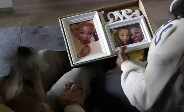 Ella Anthony and her partner Doris Ezuruike Chinons show photos of themselves during an interview in their house in Passo Corese, near Rome, Monday, March 11, 2024. Knowing that she faced a possible prison term since Nigeria criminalizes same-sex relationships, Anthony fled with her partner to Libya in 2014 and then Italy, where they both won asylum. Their claim? That they had a well-founded fear of anti-LGBTQ+ persecution back home. (AP Photo/Alessandra Tarantino)