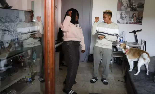 Ella Anthony, right, and her partner Doris Ezuruike Chinons, dance in their house after an interview in their house in Passo Corese, near Rome, Monday, March 11, 2024. Knowing that she faced a possible prison term since Nigeria criminalizes same-sex relationships, Anthony fled with her partner to Libya in 2014 and then Italy, where they both won asylum. Their claim? That they had a well-founded fear of anti-LGBTQ+ persecution back home. (AP Photo/Alessandra Tarantino)