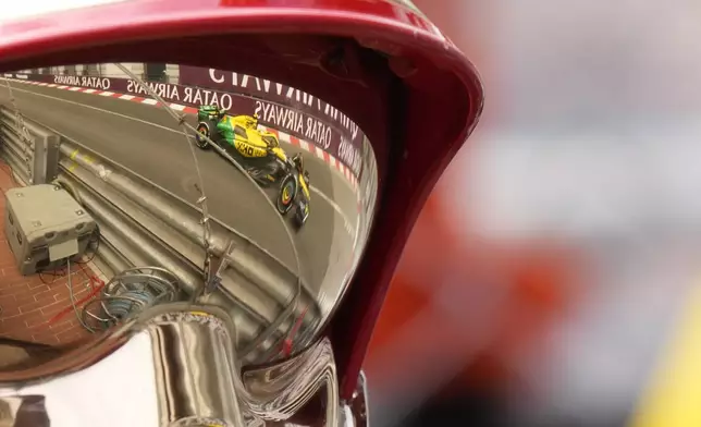McLaren driver Lando Norris of Britain is reflected in a fireman's helmet as he steers his car during the first free practice ahead of the Formula One Monaco Grand Prix at the Monaco racetrack, in Monaco, Friday, May 24, 2024. (AP Photo/Luca Bruno)