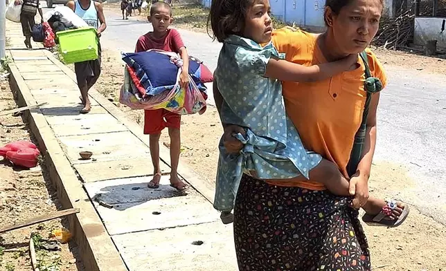 In this photo released by the Free Burma Rangers, families flee after a Buddhist monastery sheltering civilians displaced by fighting in the town of Papun, Karen state, Myanmar was attacked on March 31, 2024 by a regime warplane. (Free Burma Rangers via AP)