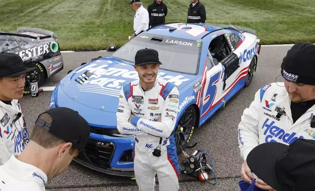 Kyle Larson, center, visits with his pit crew along pit road before a NASCAR Cup Series auto race at Kansas Speedway in Kansas City, Kan., Sunday, May 5, 2024. (AP Photo/Colin E. Braley)