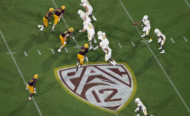FILE - The Pac-12 logo is shown during the second half of an NCAA college football game between Arizona State and Kent State, in Tempe, Ariz., Aug. 29, 2019. Southeastern Conference and Pac-12 officials are expected to provide the final approval of a $2.8 billion plan that will settle antitrust claims and set the stage for college athletes to start sharing the billions of dollars flowing to their schools. (AP Photo/Ralph Freso, File)