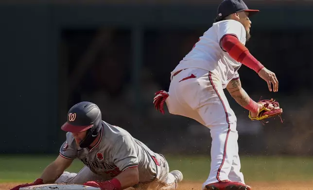 Washington Nationals' Jacob Young (30) gets past Atlanta Braves shortstop Orlando Arcia (11) on a steal in the sixth inning of a baseball game, Monday, May 27, 2024, in Atlanta. (AP Photo/Mike Stewart)
