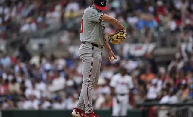Washington Nationals pitcher Mitchell Parker (70) wipes his face in the sixth inning of a baseball game against the Atlanta Braves, Monday, May 27, 2024, in Atlanta. (AP Photo/Mike Stewart)