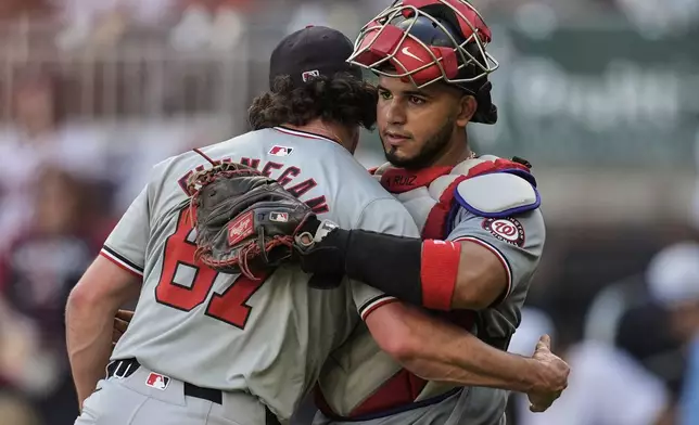 Washington Nationals' Kyle Finnegan (67) embraces catcher Keibert Ruiz (20) after a baseball game against the Atlanta Braves, Monday, May 27, 2024, in Atlanta. (AP Photo/Mike Stewart)