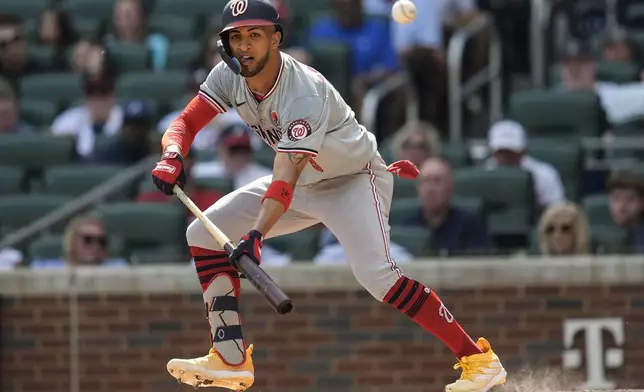 Washington Nationals' Eddie Rosario (8) attempts a bunt in the second inning of a baseball game against the Atlanta Braves, Monday, May 27, 2024, in Atlanta. (AP Photo/Mike Stewart)
