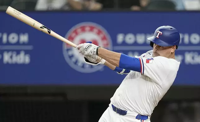 Texas Rangers' Nathaniel Lowe follows through on an RBI single in the seventh inning of a baseball game against the Washington Nationals in Arlington, Texas, Tuesday, April 30, 2024. Marcus Semien scored on the hit. (AP Photo/Tony Gutierrez)