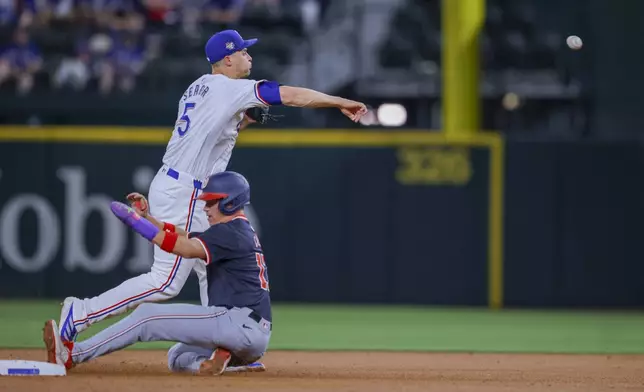 Washington Nationals' Alex Call, bottom, slides into second as Texas Rangers shortstop Corey Seager, top, throws to first for a double play during the second inning of a baseball game in Arlington, Texas, Wednesday, May 1, 2024. (AP Photo/Gareth Patterson)