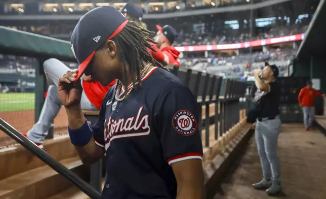 Washington Nationals shortstop CJ Abrams pulls his hat down as he walks onto the field before a baseball game against the Texas Rangers in Arlington, Texas, Wednesday, May 1, 2024. (AP Photo/Gareth Patterson)