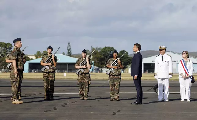 French President Emmanuel Macron stands alongside French High Commissioner to New Caledonia, Louis Le Franc, second right, during the official welcome ceremony upon his arrival at Noumea ñ La Tontouta International airport, in Noumea, New Caledonia, Thursday, May 23, 2024. Macron has landed in riot-hit New Caledonia, having crossed the globe by plane from Paris in a high-profile show of support for the French Pacific archipelago wracked by deadly unrest and where indigenous people have long sought independence from France. (Ludovic Marin/Pool Photo via AP)