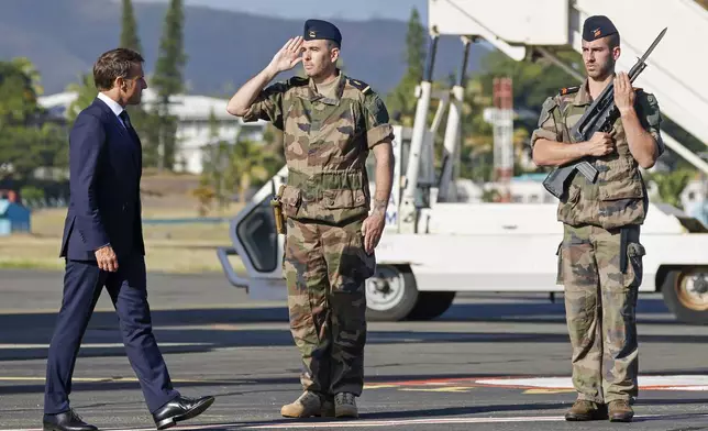 French President Emmanuel Macron inspects a guard of honor on his arrival at Noumea ñ La Tontouta International airport, in Noumea, New Caledonia, Thursday, May 23, 2024. Macron has landed in riot-hit New Caledonia, having crossed the globe by plane from Paris in a high-profile show of support for the French Pacific archipelago wracked by deadly unrest and where indigenous people have long sought independence from France. (Ludovic Marin/Pool Photo via AP)