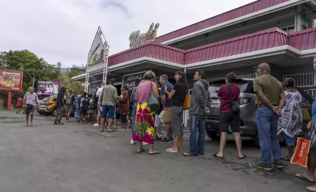 People gather queue in front a market in Noumea, New Caledonia, Wednesday May 15, 2024. France has imposed a state of emergency in the French Pacific territory of New Caledonia. The measures imposed on Wednesday for at least 12 days boost security forces' powers to quell deadly unrest that has left four people dead, erupting after protests over voting reforms. (AP Photo/Nicolas Job)