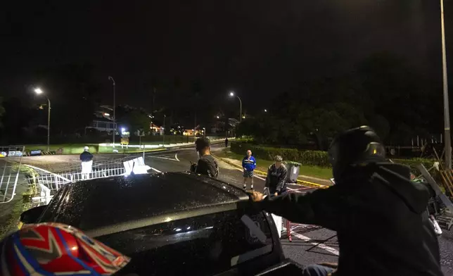 Residents stand in a blockade in Noumea, New Caledonia, Wednesday May, 15, 2024. Violence is raging across New Caledonia for the third consecutive day and France has imposed a state of emergency in the French Pacific territory. (AP Photo/Nicolas Job)