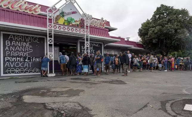 People gather queue in front a market in Noumea, New Caledonia, Wednesday May 15, 2024. France has imposed a state of emergency in the French Pacific territory of New Caledonia. The measures imposed on Wednesday for at least 12 days boost security forces' powers to quell deadly unrest that has left four people dead, erupting after protests over voting reforms. (AP Photo/Nicolas Job)