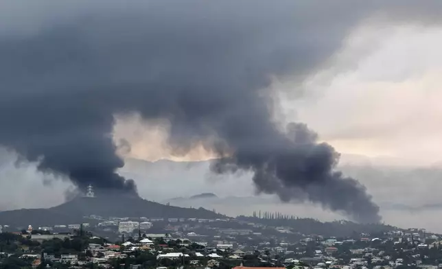 Smoke rises during protests in Noumea, New Caledonia, Wednesday May 15, 2024. France has imposed a state of emergency in the French Pacific territory of New Caledonia. The measures imposed on Wednesday for at least 12 days boost security forces' powers to quell deadly unrest that has left four people dead, erupting after protests over voting reforms. (AP Photo/Nicolas Job)