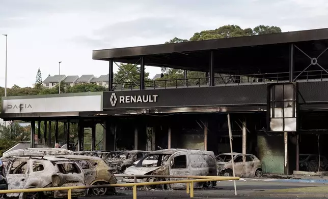 A burnt car store is pictured in Noumea, New Caledonia, Tuesday May, 14, 2024. France has imposed a state of emergency in the French Pacific territory of New Caledonia. The measures imposed on Wednesday for at least 12 days boost security forces' powers to quell deadly unrest that has left four people dead, erupting after protests over voting reforms. (AP Photo/Cedric Jacquot)