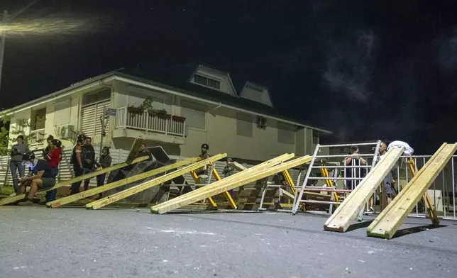 Residents stand in a blockade in Noumea, New Caledonia, Wednesday, May, 15, 2024. Violence is raging across New Caledonia for the third consecutive day and France has imposed a state of emergency in the French Pacific territory. (AP Photo/Nicolas Job)