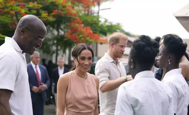 Prince Harry and Meghan meet children at the Lights Academy in Abuja, Nigeria, Friday, May 10, 2024. Prince Harry and his wife Meghan have arrived in Nigeria to champion the Invictus Games, which he founded to aid the rehabilitation of wounded and sick servicemembers and veterans. (AP Photo/Sunday Alamba)