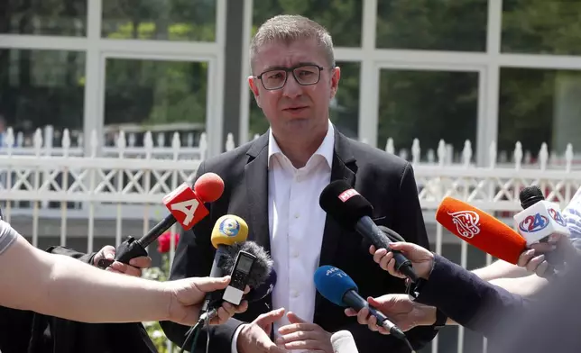 Hristijan Mickoski, the leader of the opposition center-right VMRO-DPMNE party, makes statements at a polling station in Skopje, North Macedonia, on Wednesday, May 8, 2024. Voters in North Macedonia were casting ballots on Wednesday in a parliamentary election and a presidential runoff dominated by issues including the country's path toward European Union membership, corruption and the economy. (AP Photo/Boris Grdanoski)