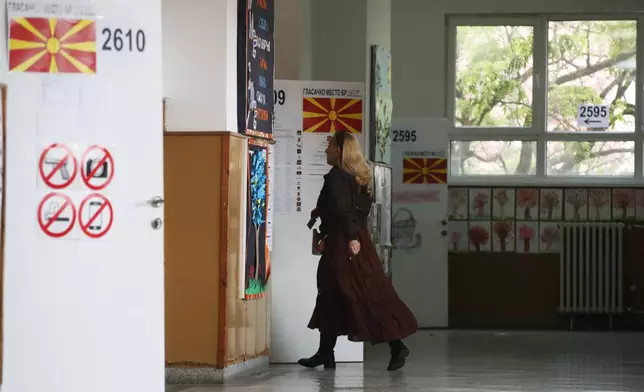 A woman enters a polling station to cast her ballots for the parliamentary election and the presidential runoff, in Skopje, North Macedonia, on Wednesday, May 8, 2024. Voters in North Macedonia go to the polls Wednesday for a double election — parliamentary and presidential — following a campaign in which the country's aspirations to join the European Union have played a central role. (AP Photo/Boris Grdanoski)