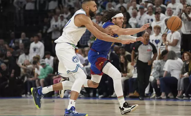 Minnesota Timberwolves center Rudy Gobert, left, and Denver Nuggets forward Aaron Gordon reach for the ball during the second half of Game 6 of an NBA basketball second-round playoff series Thursday, May 16, 2024, in Minneapolis. (AP Photo/Abbie Parr)
