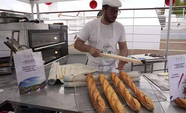 French baker Tony Dore prepares baguettes, like those that will be served during the. Olympic Games, Tuesday, April 30, 2024 in Paris. Some 40,000 meals will be served each day during the Games to over 15,000 athletes housed at the Olympic village. (AP Photo/Michel Euler)