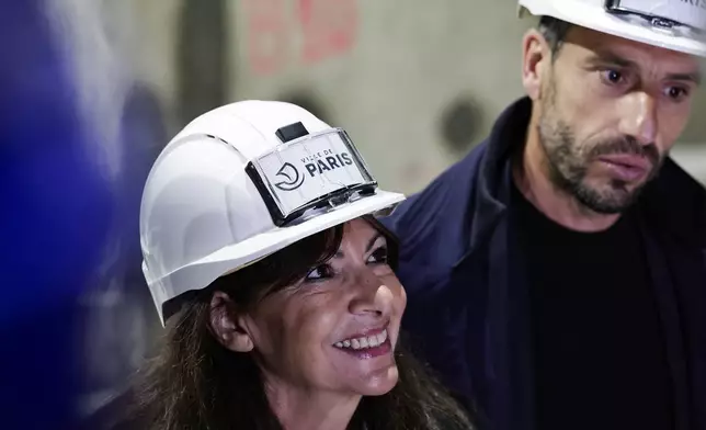 Paris' mayor Anne Hidalgo, left, and President of the Paris 2024 Olympics and Paralympics Organizing Committee Tony Estanguet the Austerlitz inaugurate the wastewater and rainwater storage basin, which is intended to make the Seine river swimmable during the Paris 2024 Olympic Games, in Paris, Thursday, May 2, 2024. The works underground next to Paris' Austerlitz train station are part of a 1.5 billion euro effort to clean up the Seine so it can host marathon swimming and triathlon events at the July 26-Aug 11 Summer Games and be opened to the general public for swimming from 2025. (Stephane de Sakutin, Pool via AP)
