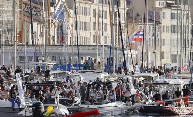 Spectators on boats watch the torch arrival ceremony in Marseille, southern France, Wednesday May 8, 2024. French Olympic swimmer Florent Manaudou became the first Olympic torch carrier in France after the Olympic flame arrived in Marseille's Old Port Wednesday on a majestic three-mast ship from Greece for the welcoming ceremony at sunset in the city's Old Port. (Ludovic Marin, Pool via AP)