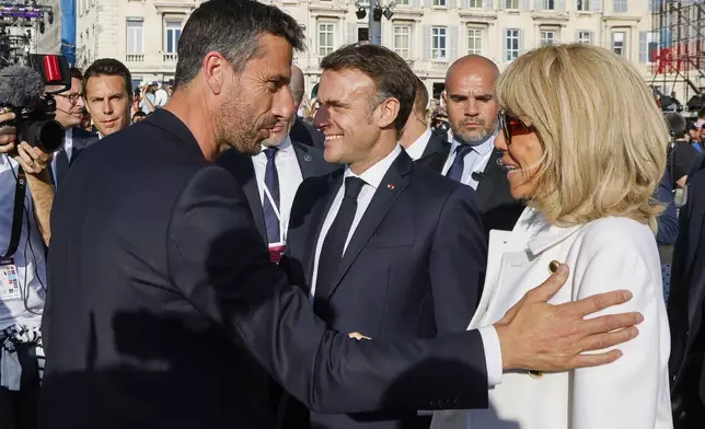 President of the Paris 2024 Olympics and Paralympics Organizing Committee Tony Estanguet, left, French President Emmanuel Macron's wife Brigitte Macron during the Olympic torch arrival ceremony in Marseille, southern France, Wednesday May 8, 2024. The Olympic flame arrived in Marseille's Old Port Wednesday on a majestic three-mast ship from Greece for the welcoming ceremony at sunset in the city's Old Port. (Ludovic Marin, Pool via AP)