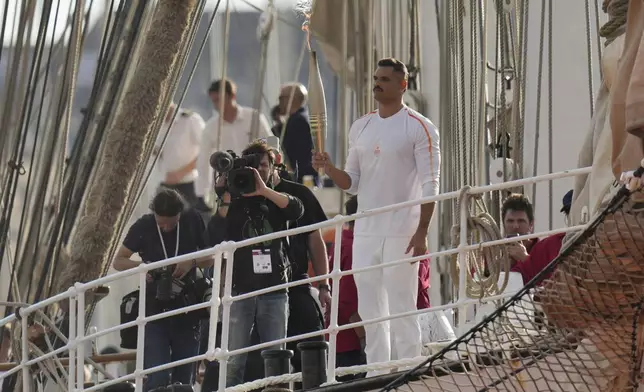 First torch carrier in France French Olympic swimmer Florent Manaudou holds the Olympic torch aboard The Belem, the three-masted sailing ship in the Old port of Marseille, southern France, Wednesday, May 8, 2024. After leaving Marseille, a vast relay route is undertaken before the torch odyssey ends on July 27 in Paris. The Paris 2024 Olympic Games will run from July 26 to Aug.11, 2024. (AP Photo/Thibault Camus)