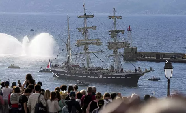 Crowds watch as the Belem, the three-masted sailing ship bringing the Olympic flame from Greece, enters the Old Port in Marseille, southern France, Wednesday, May 8, 2024. After leaving Marseille, a vast relay route is undertaken before the torch odyssey ends on July 27 in Paris. The Paris 2024 Olympic Games will run from July 26 to Aug.11, 2024. (AP Photo/Laurent Cipriani)