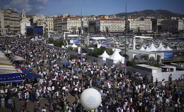 People gather to watch the welcoming ceremony of Belem, the three-masted sailing ship which is carrying the Olympic flame, in Marseille, southern France, Wednesday, May 8, 2024. The torch was lit in Greece last month before it was officially handed to France. The Paris 2024 Olympic Games will run from July 26 to Aug.11, 2024. (AP Photo/Daniel Cole)