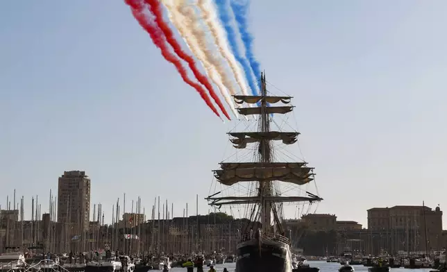 The French acrobatic flying team Patrouille de France flies over the French 19th-century three-mast ship Belem during the torch arrival ceremony in Marseille, southern France, Wednesday May 8, 2024. The Olympic flame arrived in Marseille's Old Port Wednesday on a majestic three-mast ship from Greece for the welcoming ceremony at sunset in the city's Old Port. (Ludovic Marin, Pool via AP)