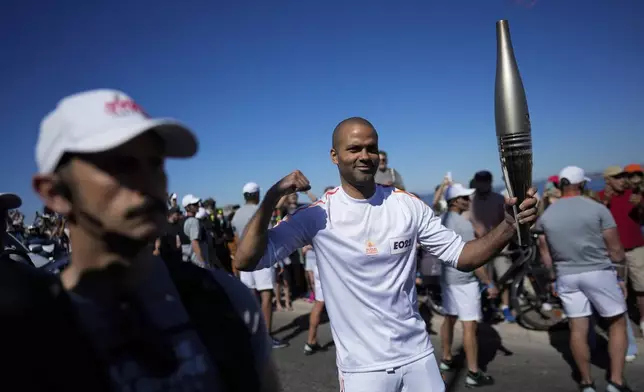 French torchbearer Tony Parker participates in the first stage of the Olympic torch relay in Marseille, southern France, Thursday, May 9, 2024. Torchbearers are to carry the Olympic flame through the streets of France' s southern port city of Marseille, one day after it arrived on a majestic three-mast ship for the welcoming ceremony. (AP Photo/Thibault Camus)